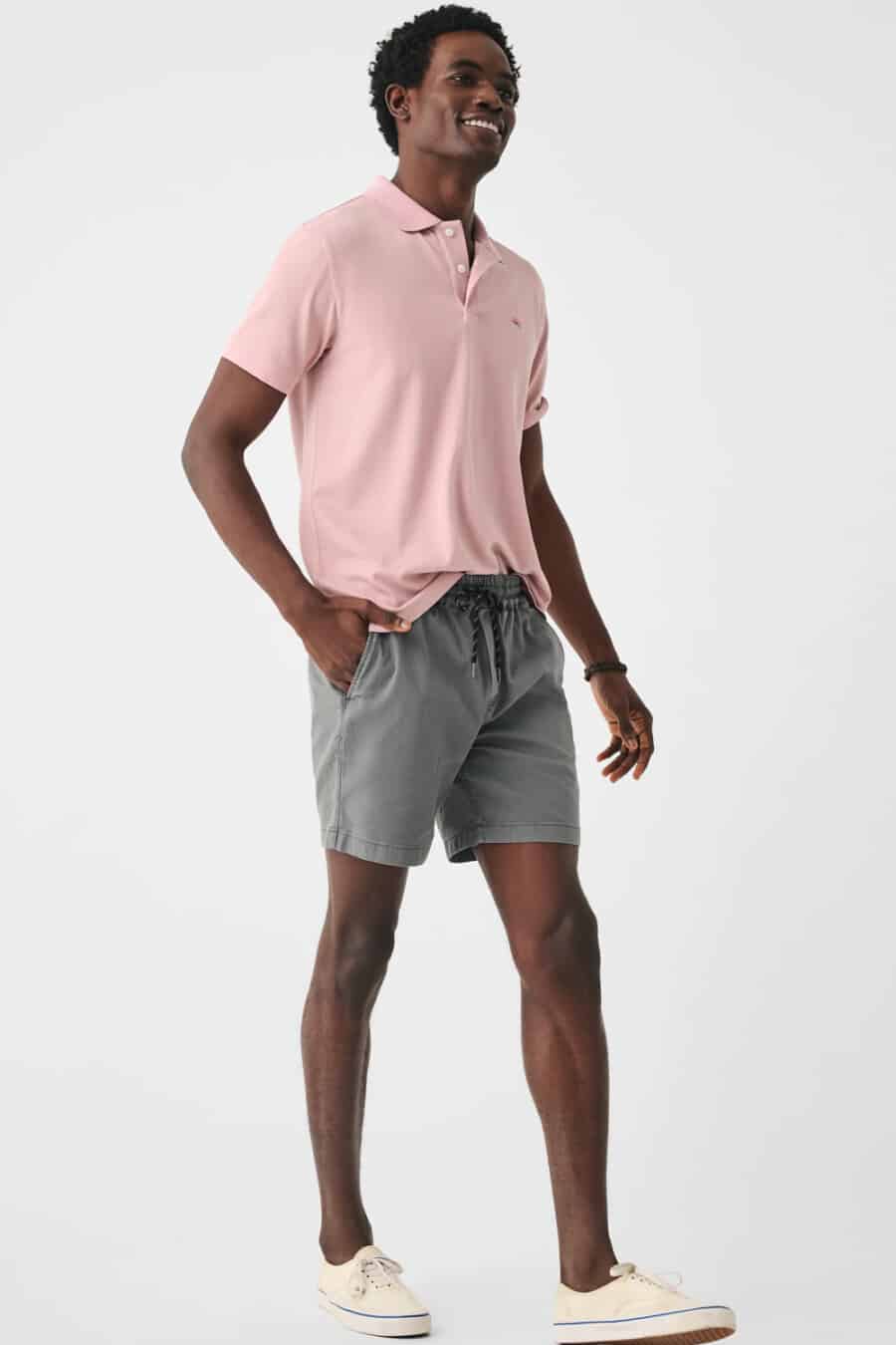 Men's grey drawstring shorts, light pink polo shirt and cream skate shoe sneakers outfit