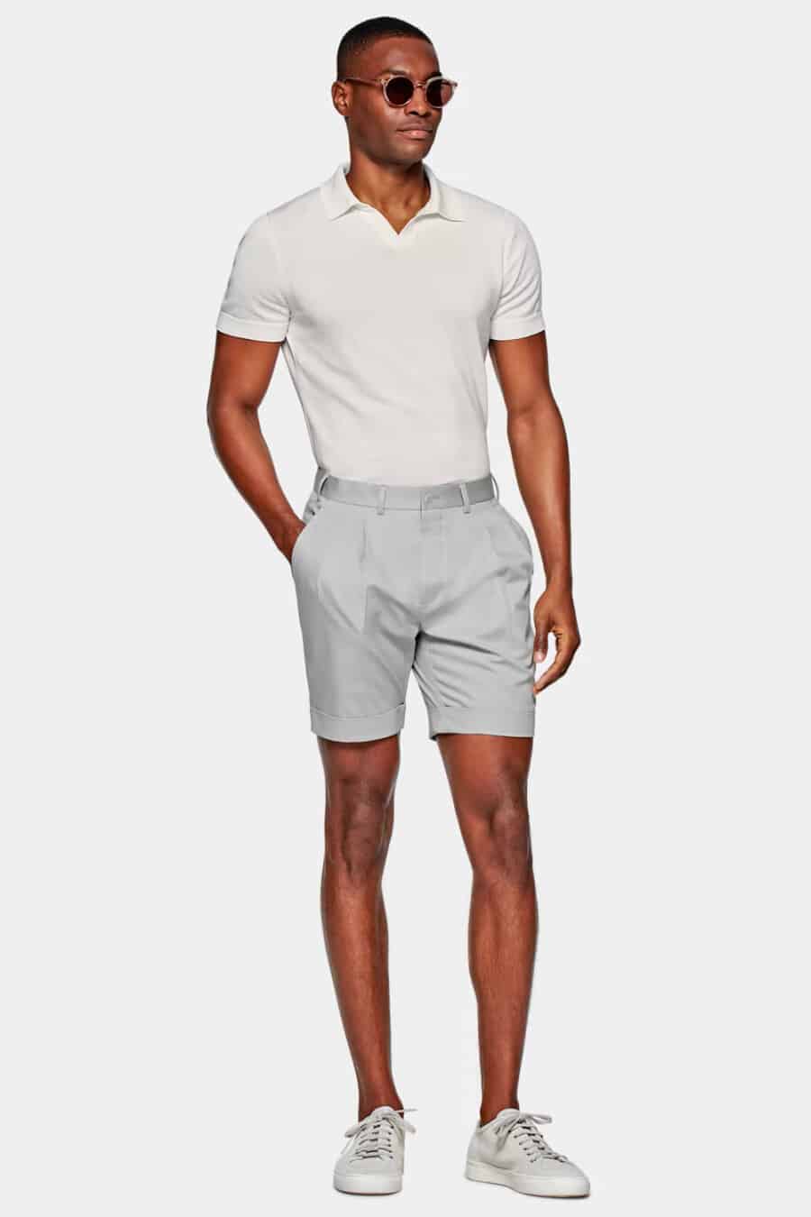 Men's light grey tailored shorts with white knitted polo shirt tucked in with light grey sneakers outfit