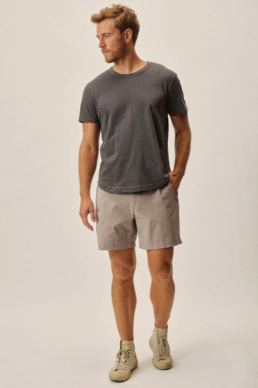 Men's light grey shorts, charcoal T-shirt and light grey high-top sneakers