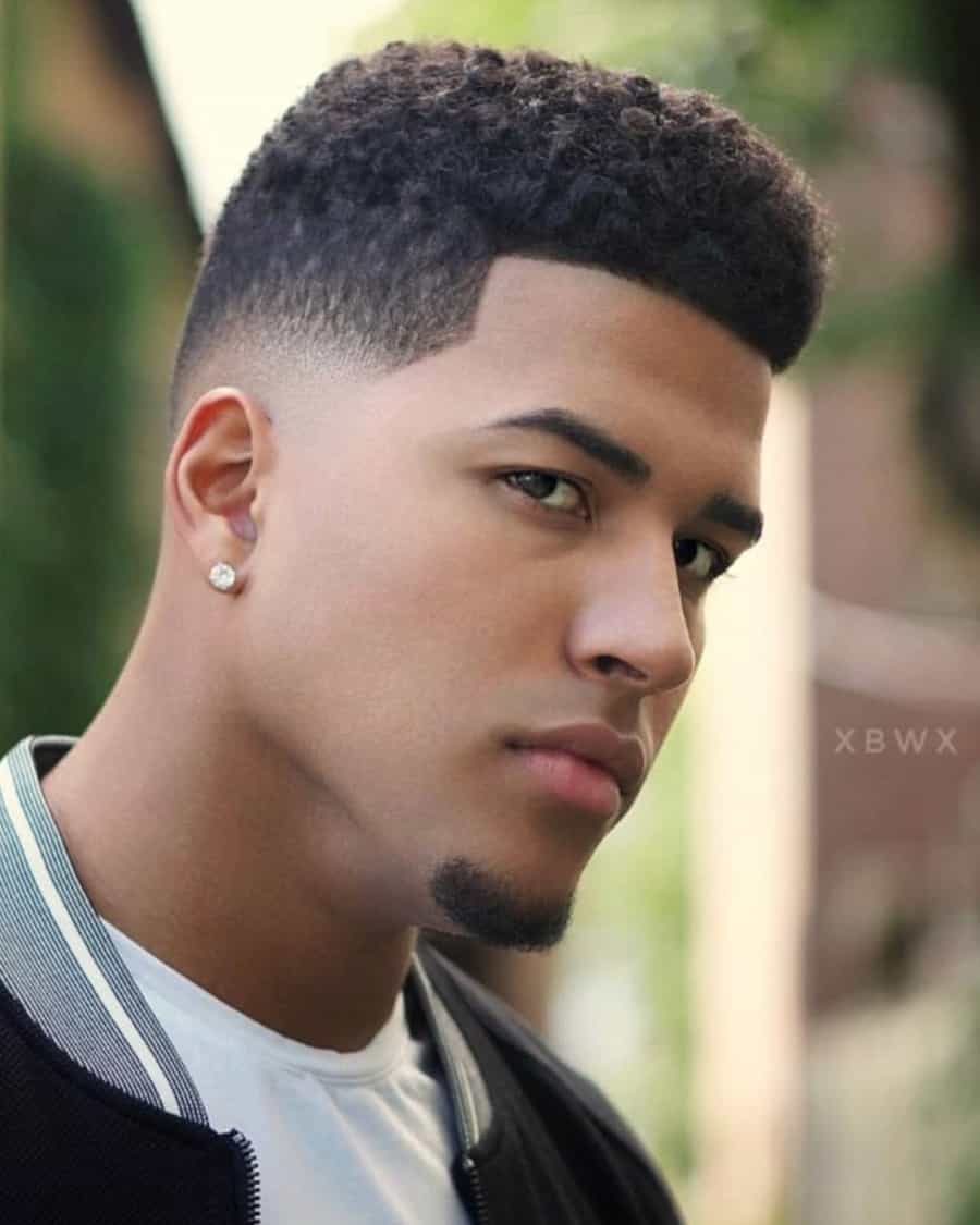 Black man with short neat afro and low skin fade haircut
