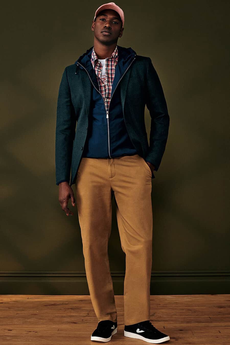 Men's brown pants, check shirt, navy zip up hoodie, green-blue blazer and black canvas skate shoes outfit
