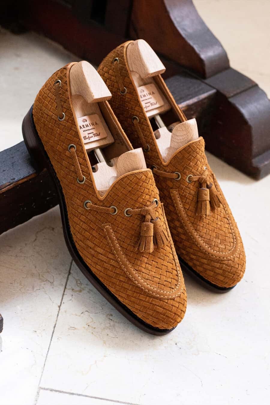 A pair of luxury tan suede woven tassel loafers by Carmina