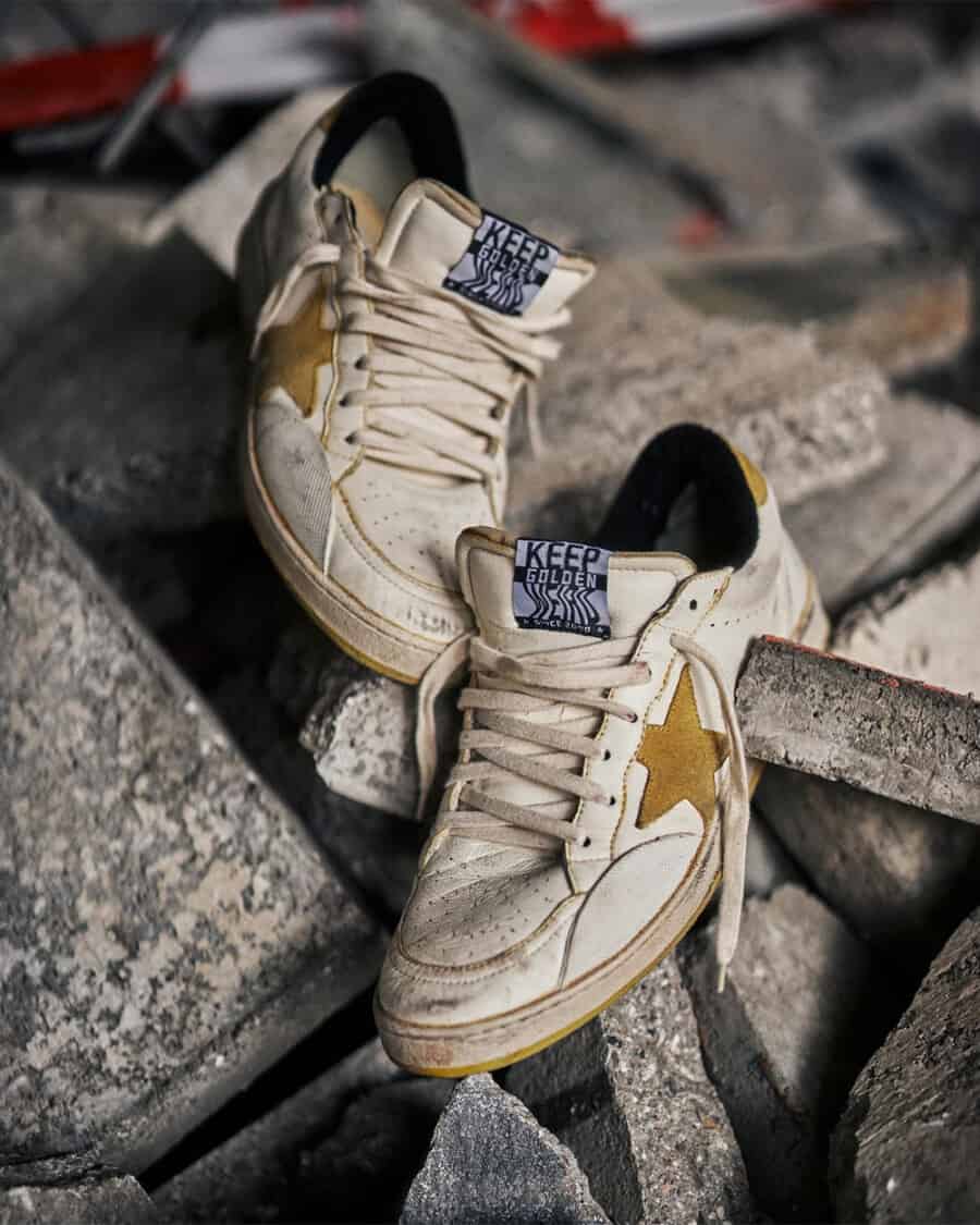 A pair of distressed Golden Goose sneakers on concrete slabs