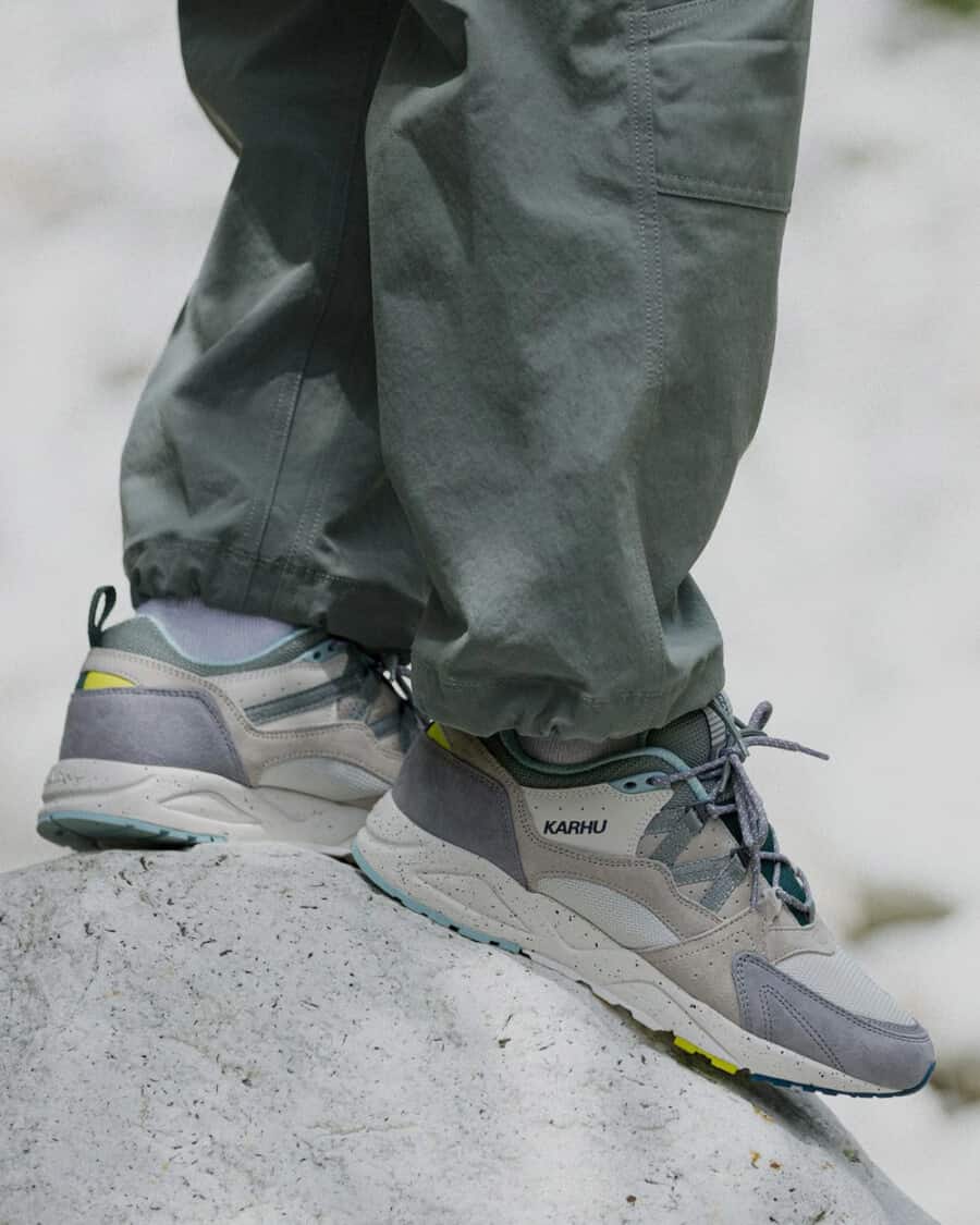 Man wearing grey Karhu sneakers with green combat pants