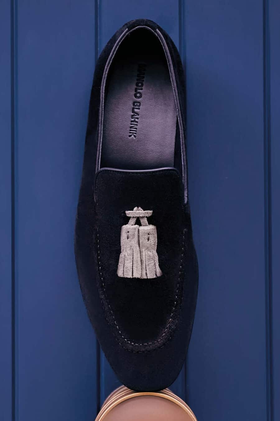 A luxury men's Manolo Blahnik black suede loafer with grey suede tassels