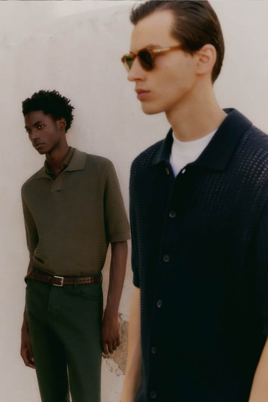 Black man and white man wearing knitted navy and green shirts by Massimo Dutti