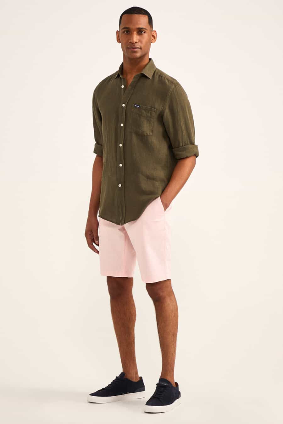 Men's pale pink shorts, olive green shirt and navy suede sneakers outfit
