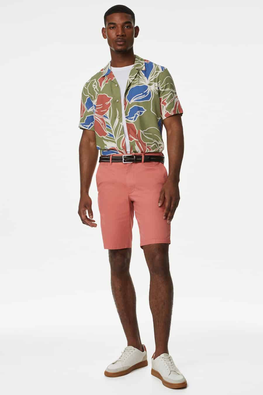 Men's pink shorts, tucked in green patterned short sleeve shirt, white T-shirt and off-white gum sole sneakers outfit