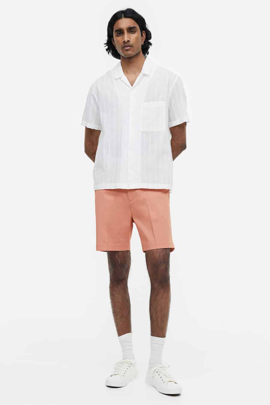 Men's pink shorts, white Cuban collar shirt, white socks and white sneakers outfit