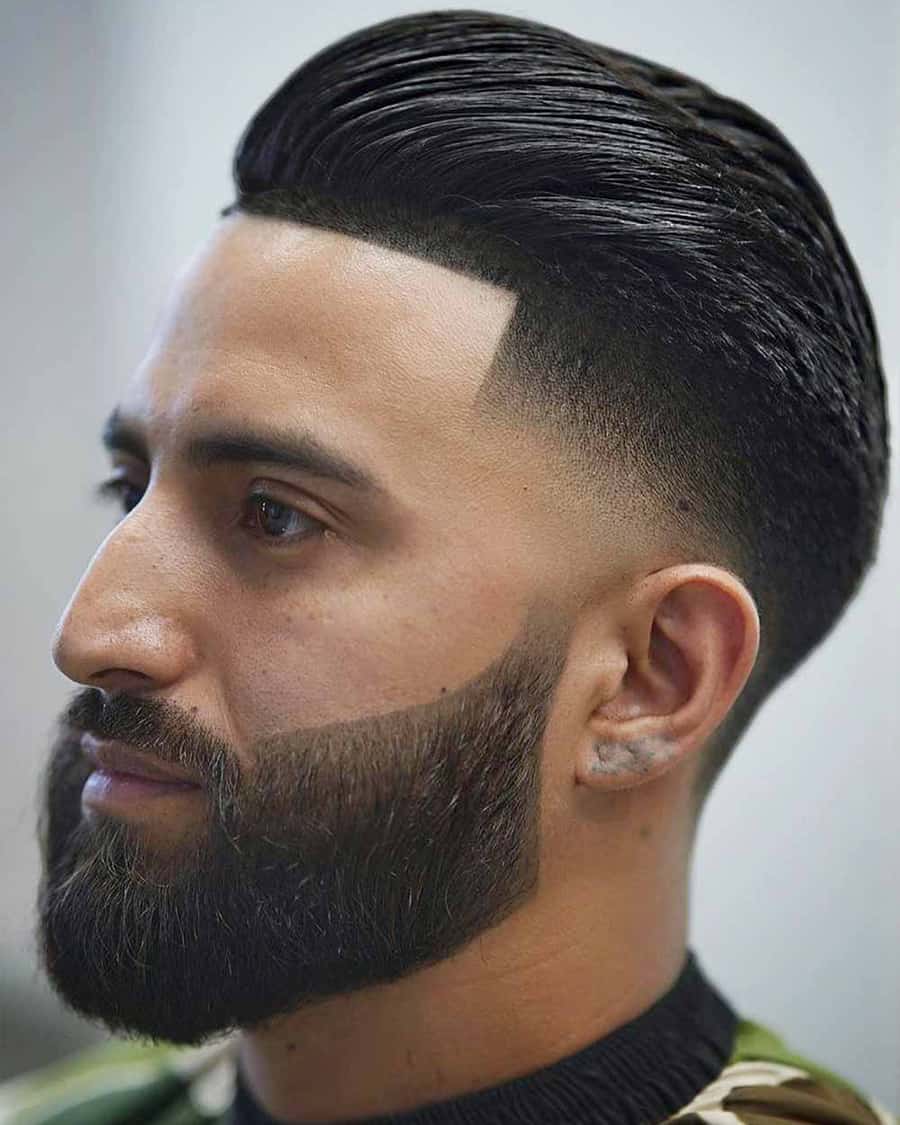 Men's slick back pompadour hairstyle with low skin fade