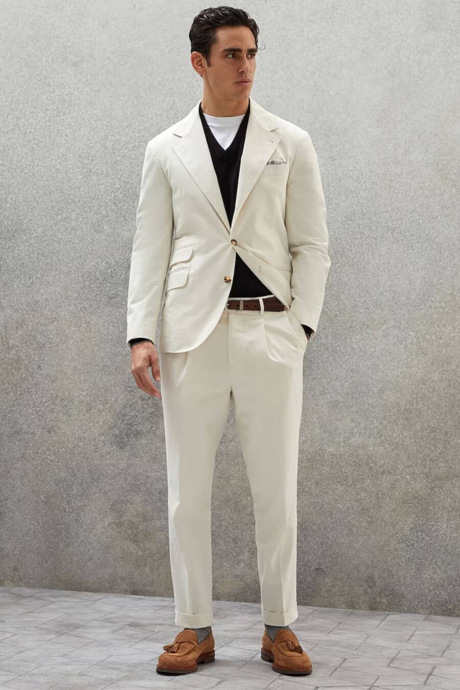 Men's cream suit, white T-shirt, black v-neck sweater and tan suede tassel loafers outfit