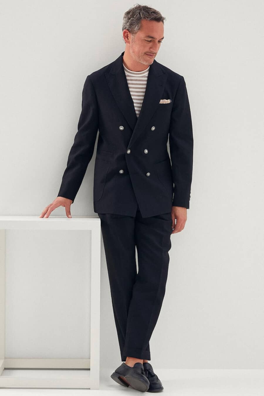 Men's double-breasted navy suit, striped T-shirt and black tassel loafers outfit