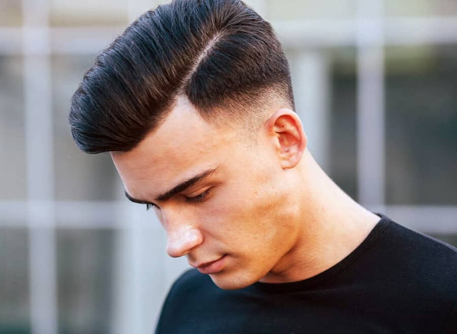 Man with a comb over low skin fade haircut