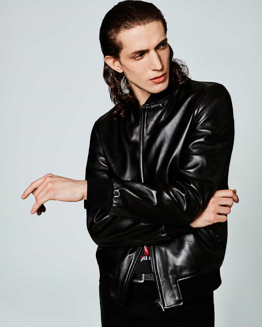 Man wearing high shine leather bomber jacket with black T-shirt and black pants