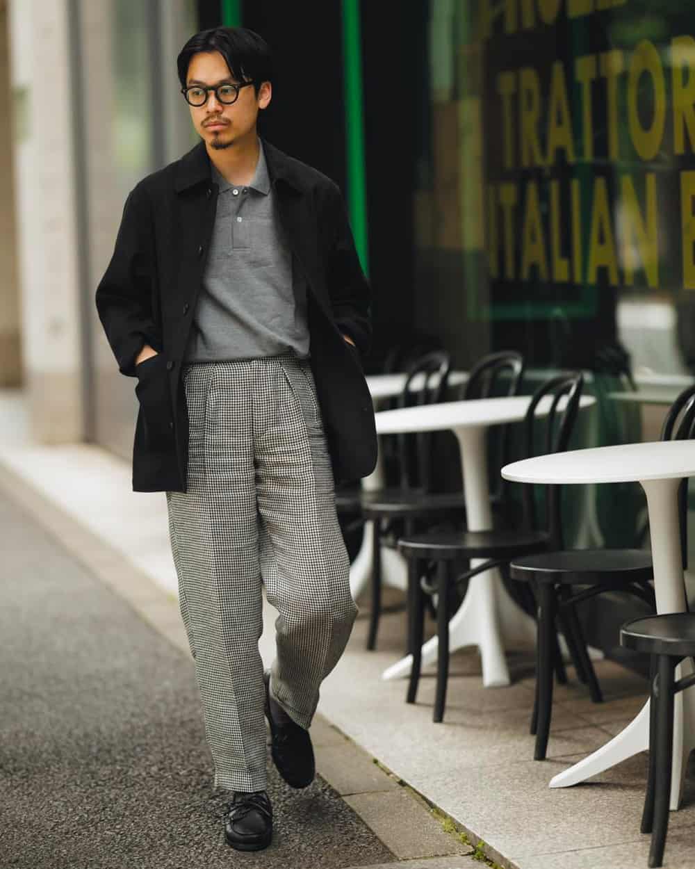 Asian man wearing full leg grey tailored pants with a grey polo shirt tucked in and smart black jacket over the top, all by Beams