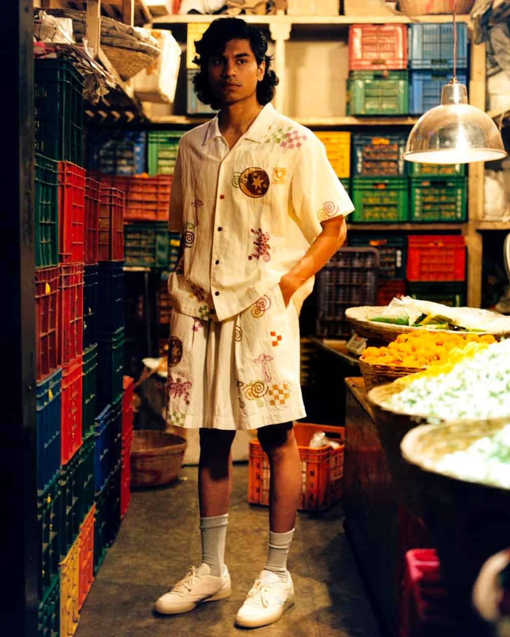 Man wearing a patterned white co-ord with grey socks and white sneakers by Story MFG 