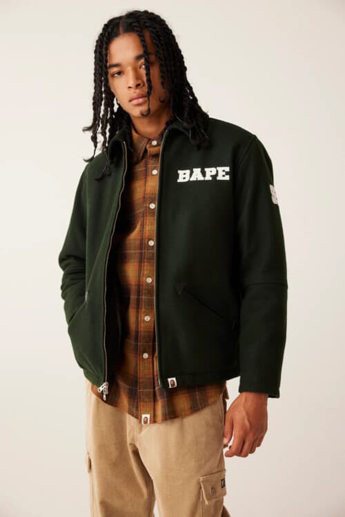 Man wearing A Bathing Ape / BAPE brown/orange check shirt, green collared logo jacket and khaki cargo pants