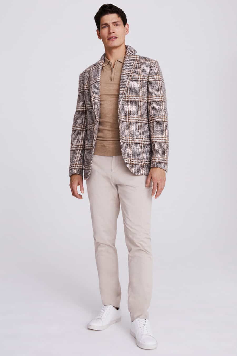 Men's stone grey chinos, brown zip-neck polo shirt, grey-brown checked blazer and white sneakers outfit