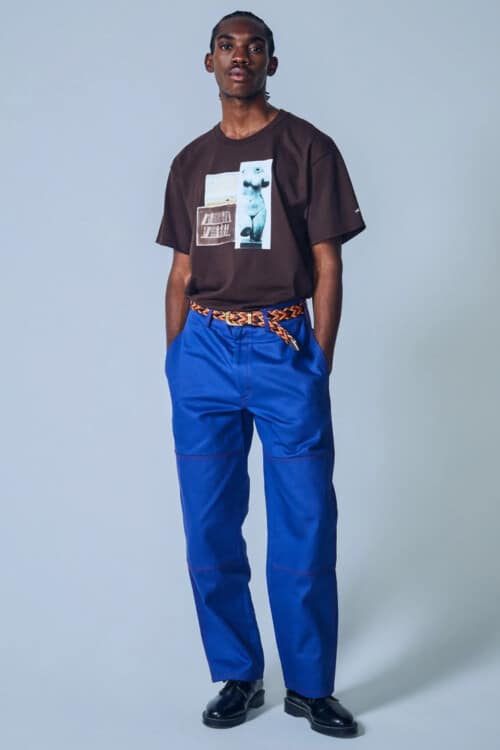 Men's black printed graphic Noah T-shirt, bright blue loose pants, black Derby shoes and brown woven belt outfit