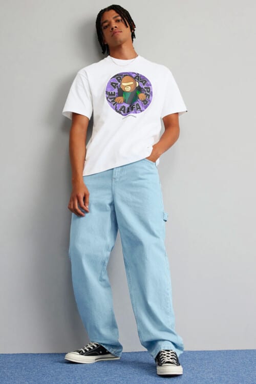 Men's printed BAPE T-shirt in white, loose/baggy pale wash jeans and black canvas sneakers outfit