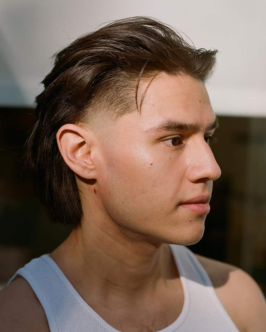 Man with long swept back hair and an undercut with a skin fade