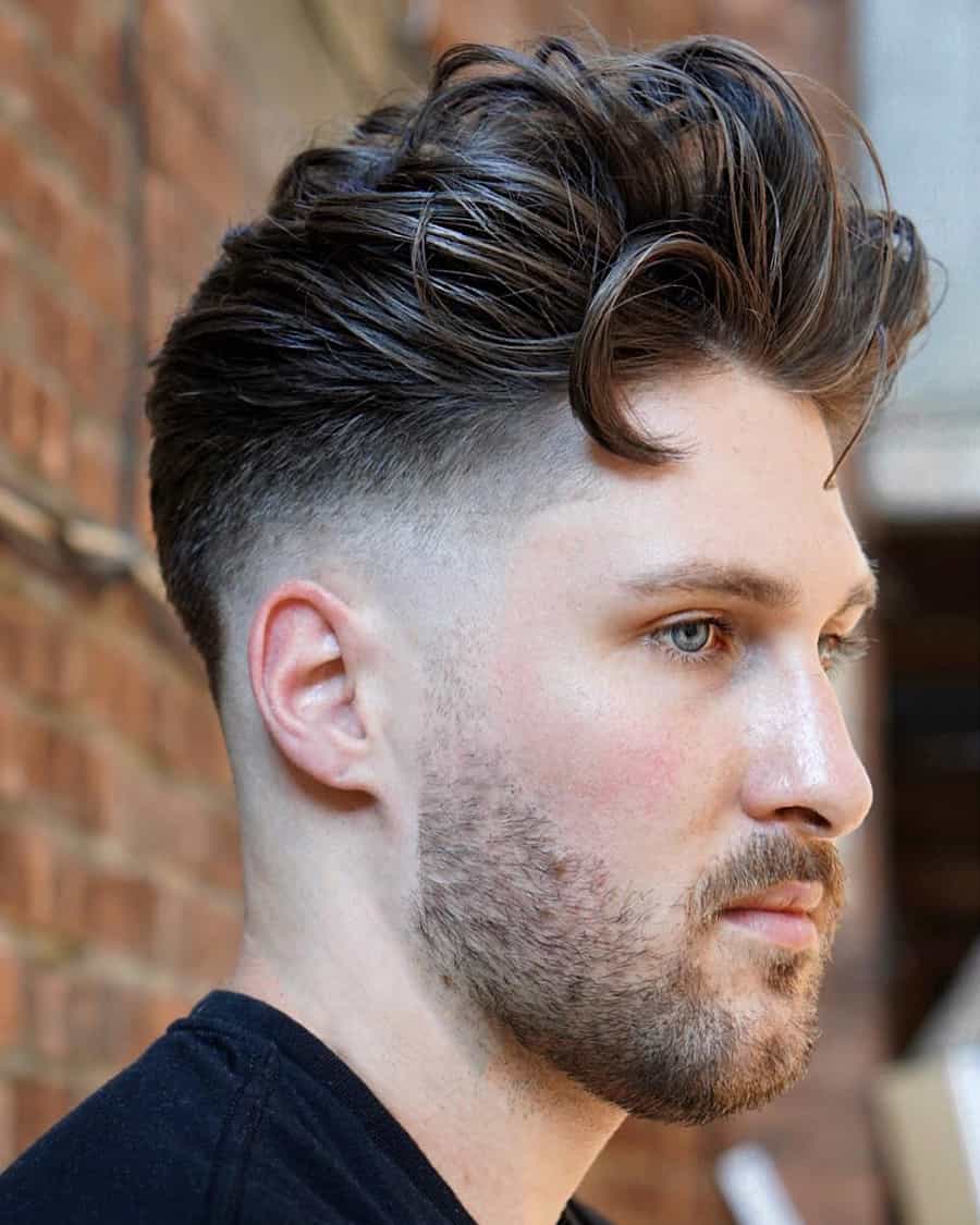 Man with loose long sweep back quiff haircut and high skin fade