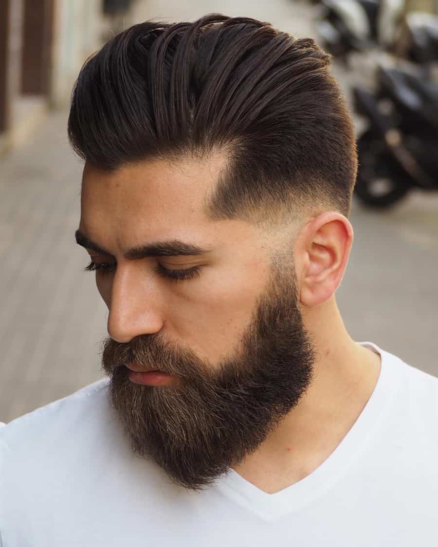 Man with long pompadour haircut, low skin fade and bushy beard