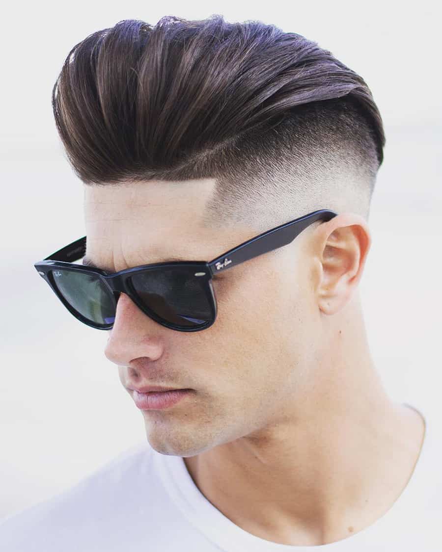 Man with long pompadour with disconnected undercut and high skin fade