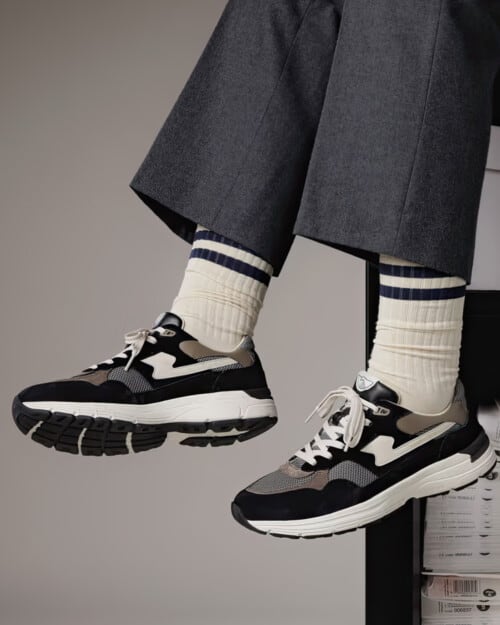 Black/grey Stepney Workers Club Amiel S-Strike sneakers worn on feet with off-white socks and grey tailored pants