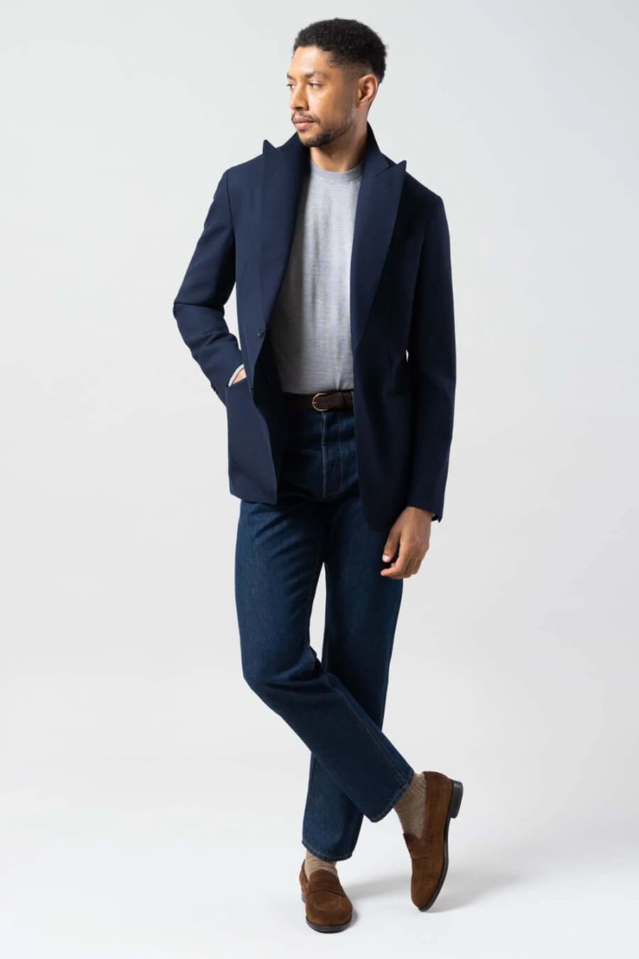 Men's Navy peak lapel blazer, dark jeans, grey tucked in T-shirt, brown socks and brown suede penny loafers outfit