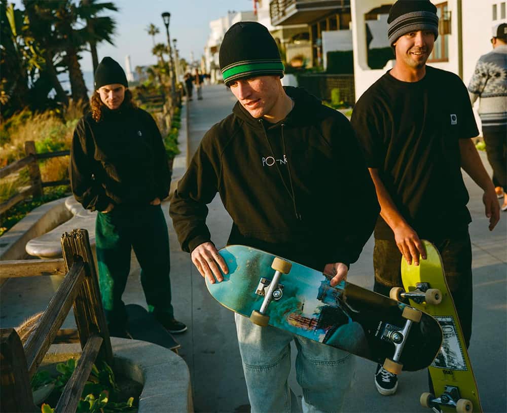 Three skateboarders on the street holding skateboards dressed in Polar Skate Co clothing