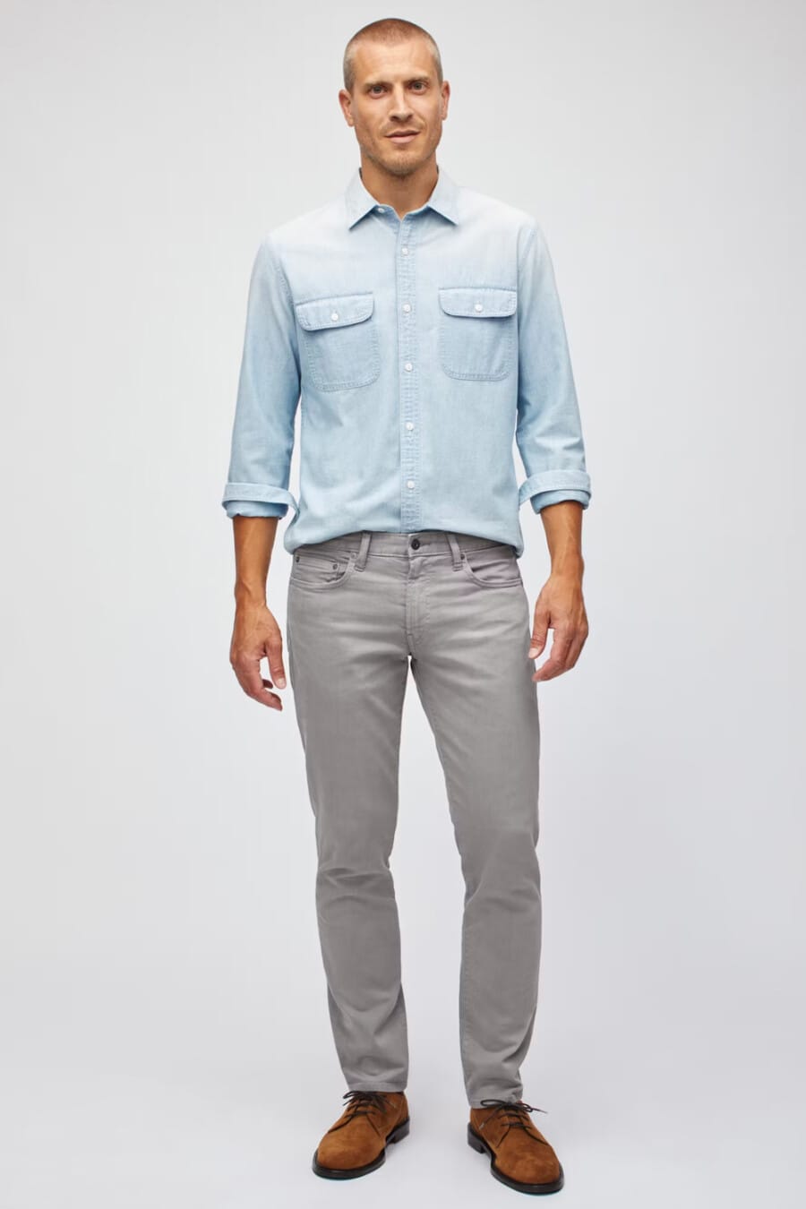 Men's grey jeans, light blue denim shirt and brown suede Derby shoes outfit