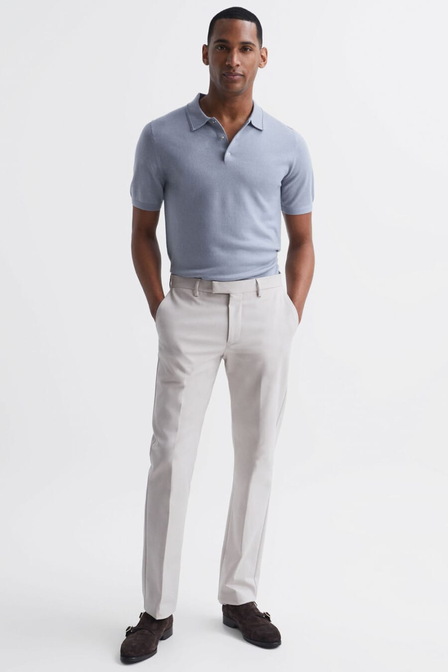 Men's light grey tailored pants, light blue knitted polo shirt and brown double monk-strap shoes outfit