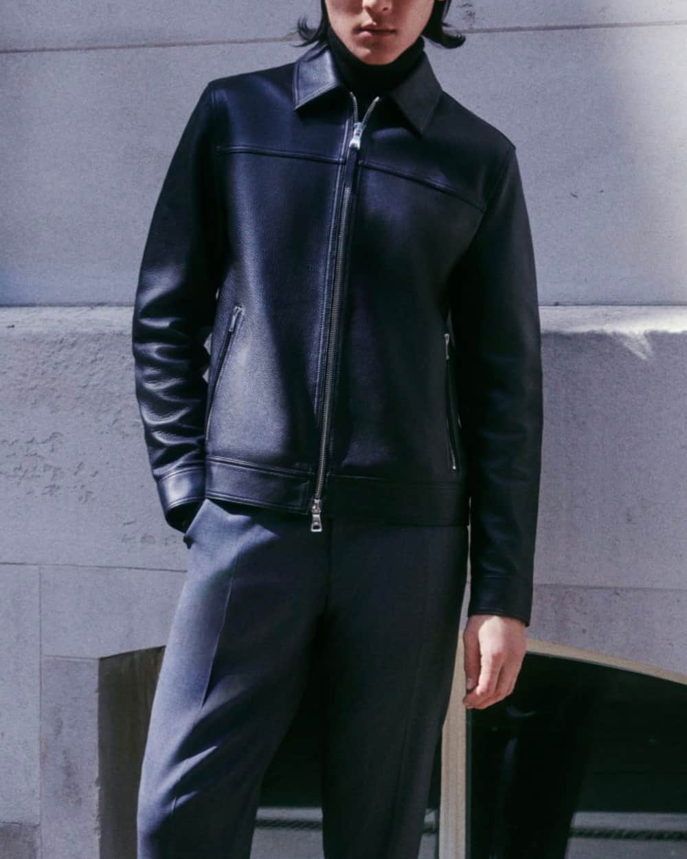 Man wearing black tailored pants, black turtleneck and black collar leather blouson jacket by Mr P