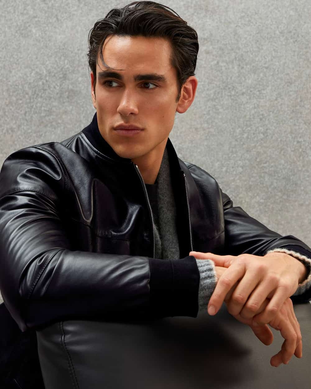 Man wearing Brunello Cucinelli black leather bomber jacket with grey sweater