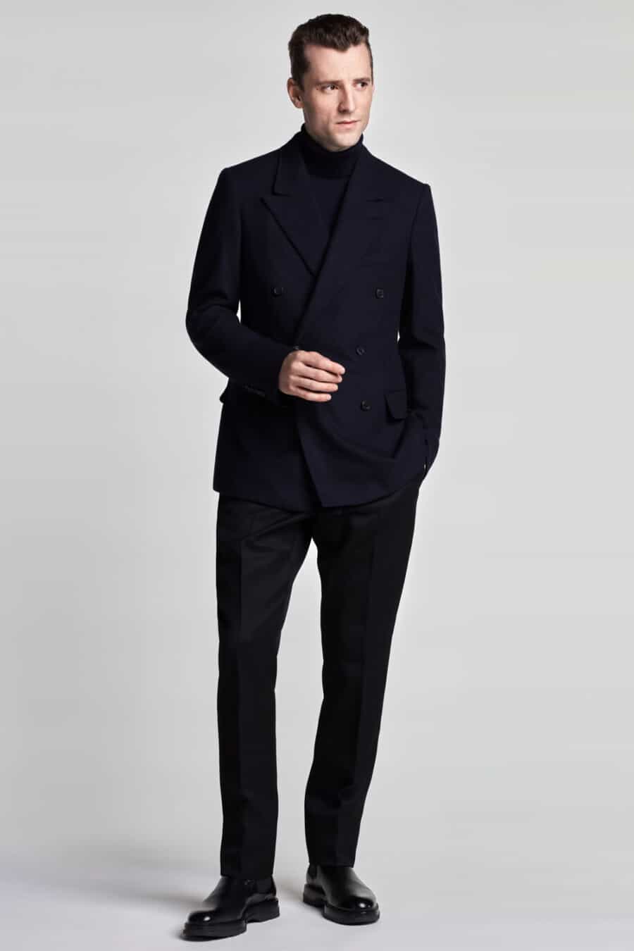 Men's navy double-breasted suit, navy turtleneck and black leather Chelsea boots outfit