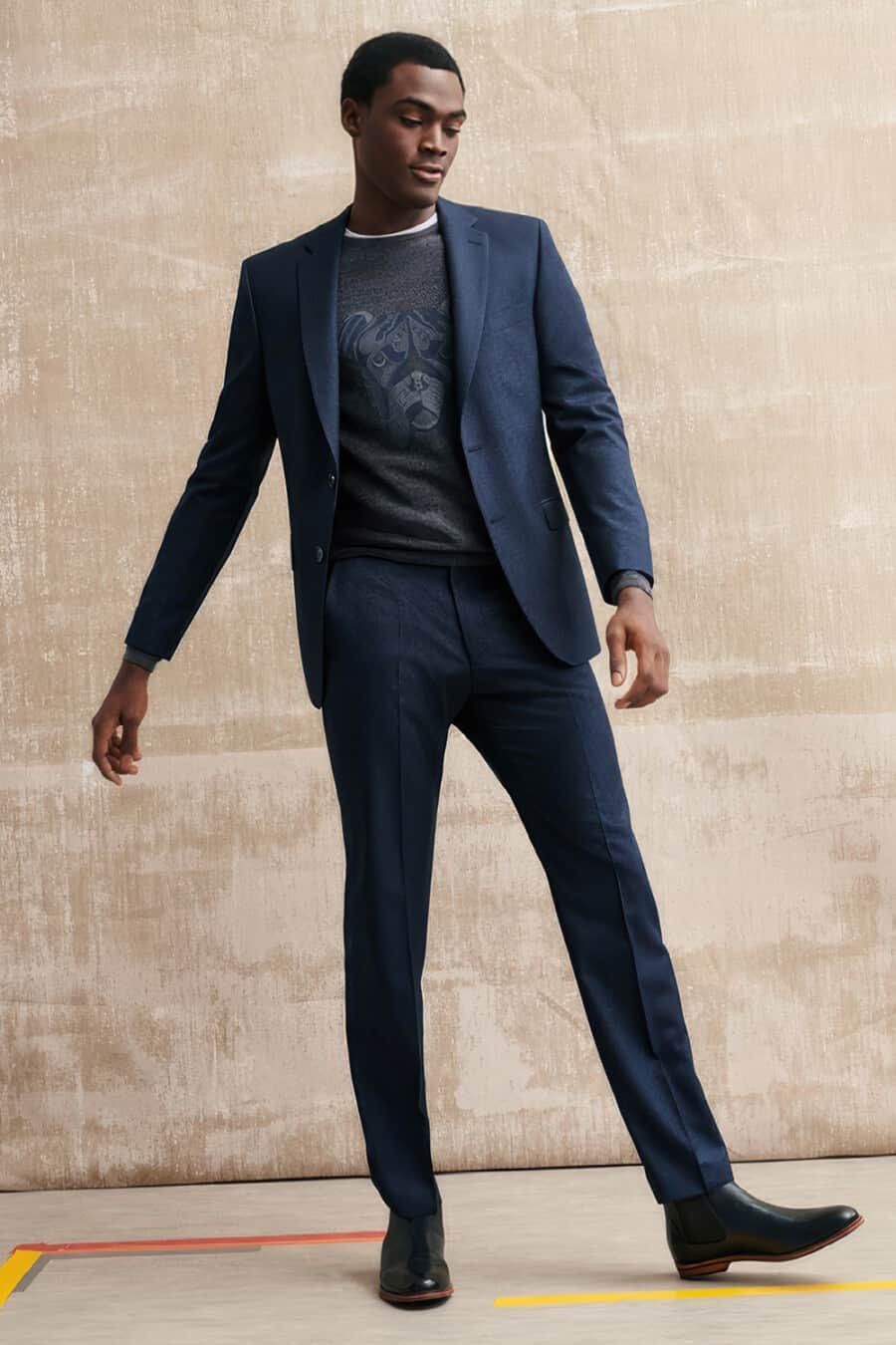 Men's blue suit, printed grey sweatshirt and black leather Chelsea boots outfit