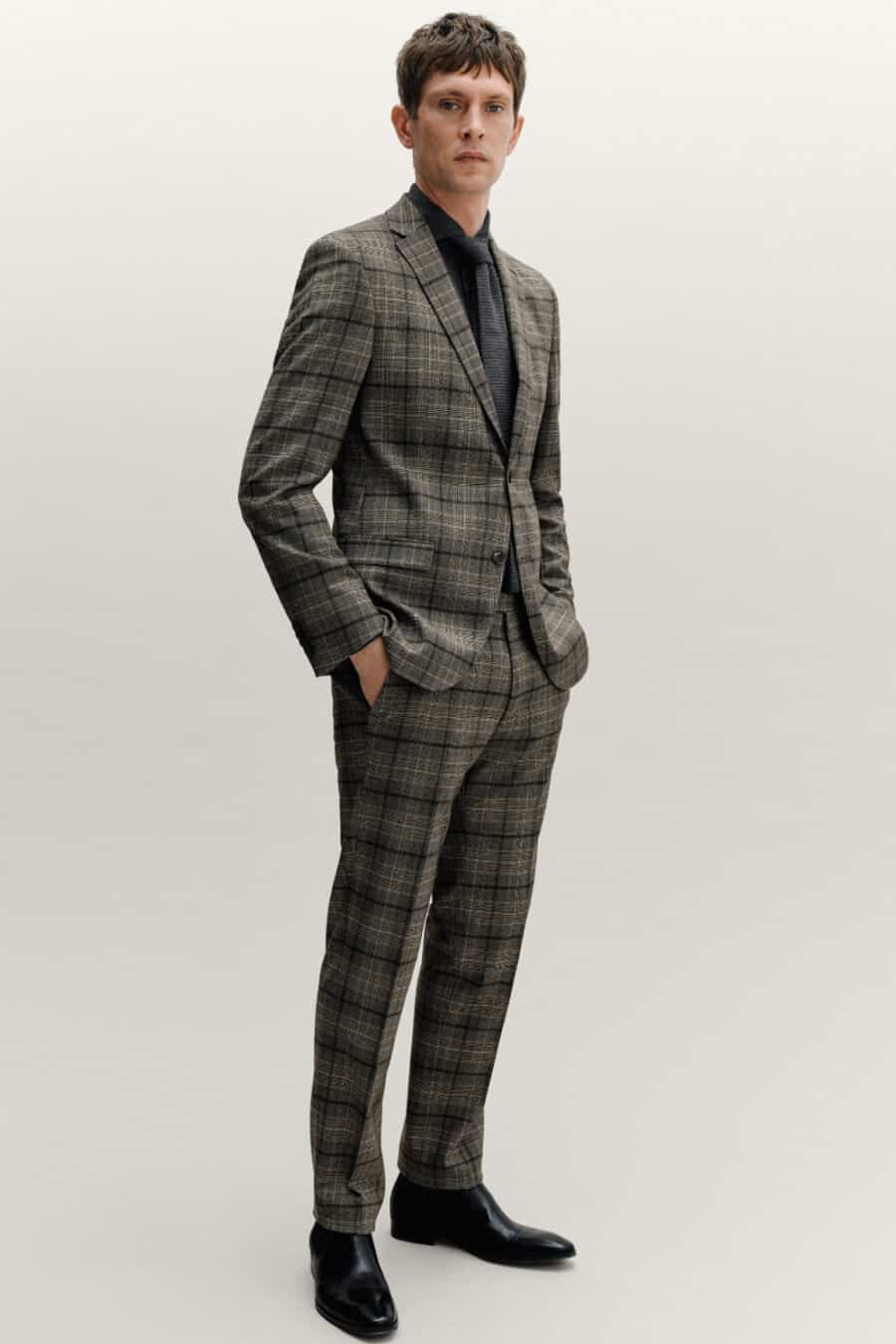 Men's grey and black check suit, black shirt, charcoal tie and black leather Chelsea boots outfit