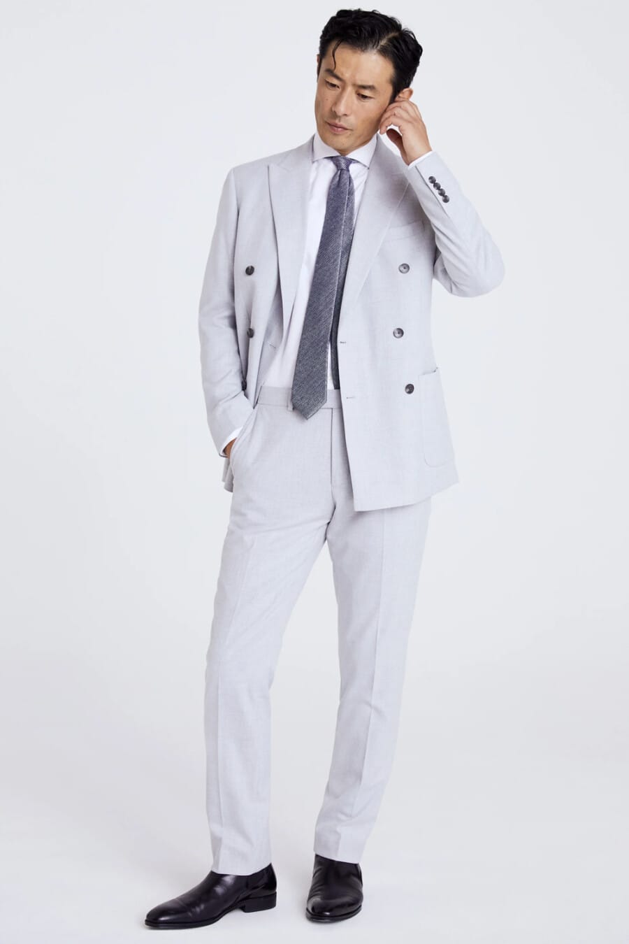 Men's light grey-blue double-breasted suit, white shirt, grey tie and black leather Chelsea boots outfit
