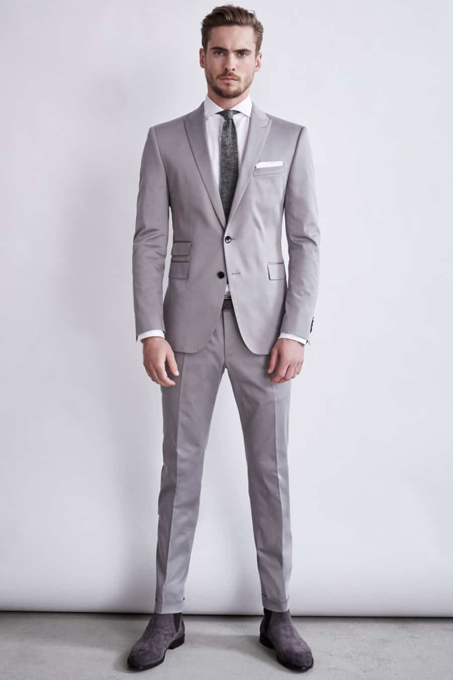 Men's light grey suit, white shirt, charcoal tie and grey suede Chelsea boots outfit