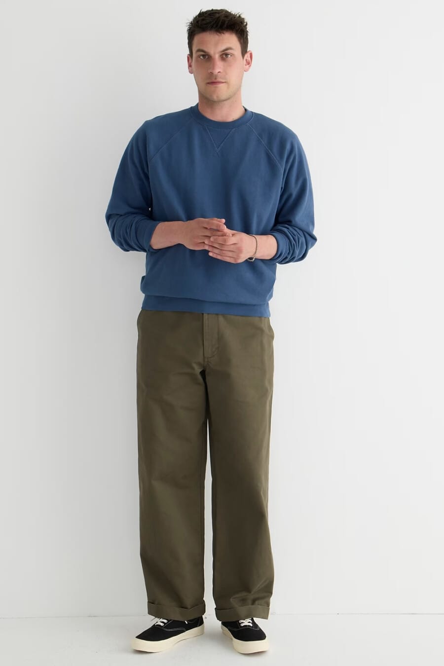 Men's green wide-leg pants, petrol blue sweatshirt and black skate shoes outfit