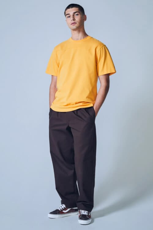 Men's brown wide-leg-pants, orange/yellow T-shirt and skate shoes outfit