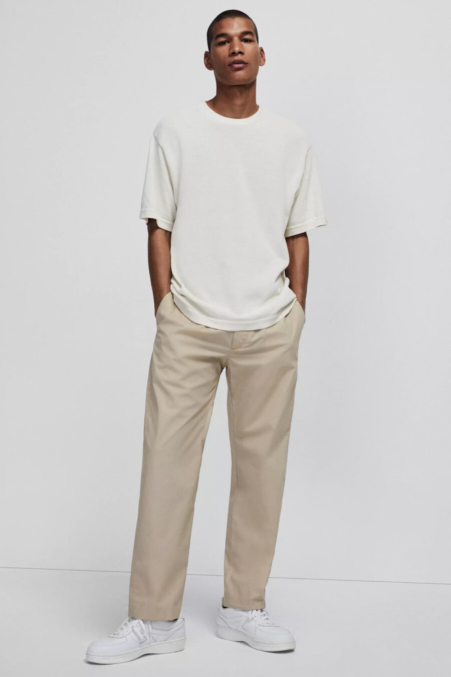 Men's wide-leg beige chinos, slouchy oversized white T-shirt and chunky white sneakers outfit