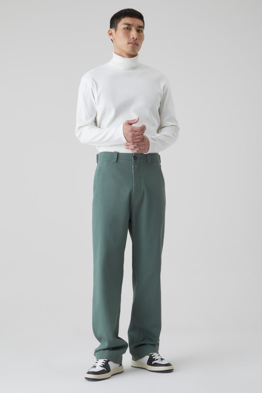 Men's green wide-leg pants, tucked in white turtleneck and black and white chunky sneakers outfit