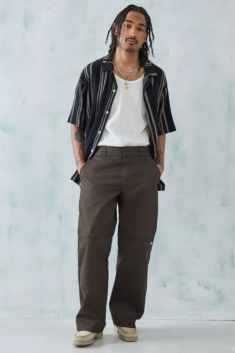 Men's wide-leg brown double knee pants, white vest, black and grey stripe short sleeve shirt and taupe boots outfit