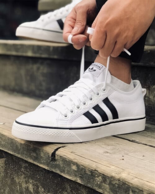 Adidas Nizza RF Sneaker in white canvas worn on feet with invisible socks