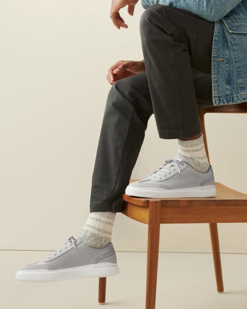 Cole Haan Men's GrandPrø Rally T-toe Canvas Sneaker worn on feet with grey socks and dark grey pants