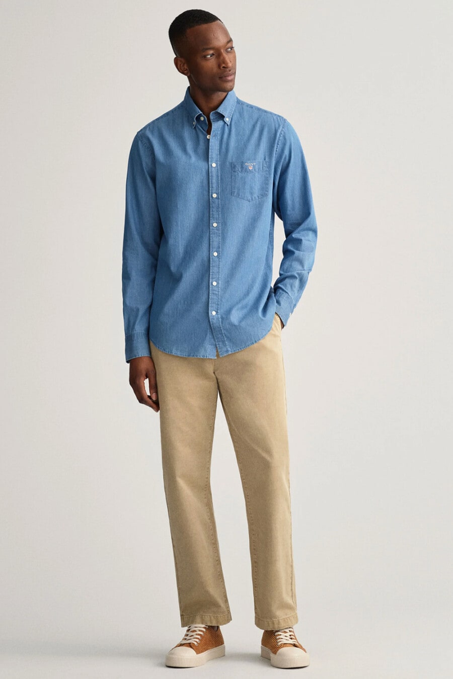 Men's khaki pants, blue Oxford shirt and brown canvas sneakers outfit