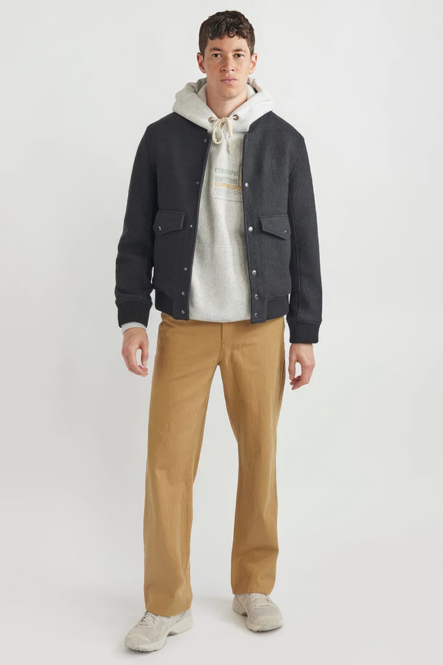 Men's khaki pants, grey hoodie, navy wool bomber jacket and grey chunky sneakers outfit