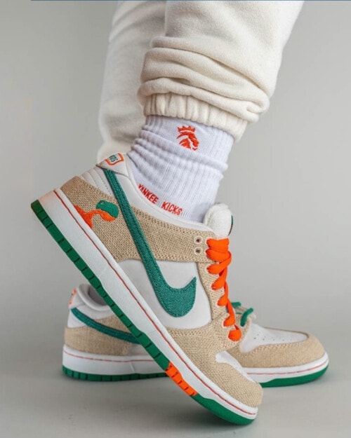 Jarritos x Nike SB Dunk Low 'Phantom' sneakers worn on feet with white socks and beige sweatpants